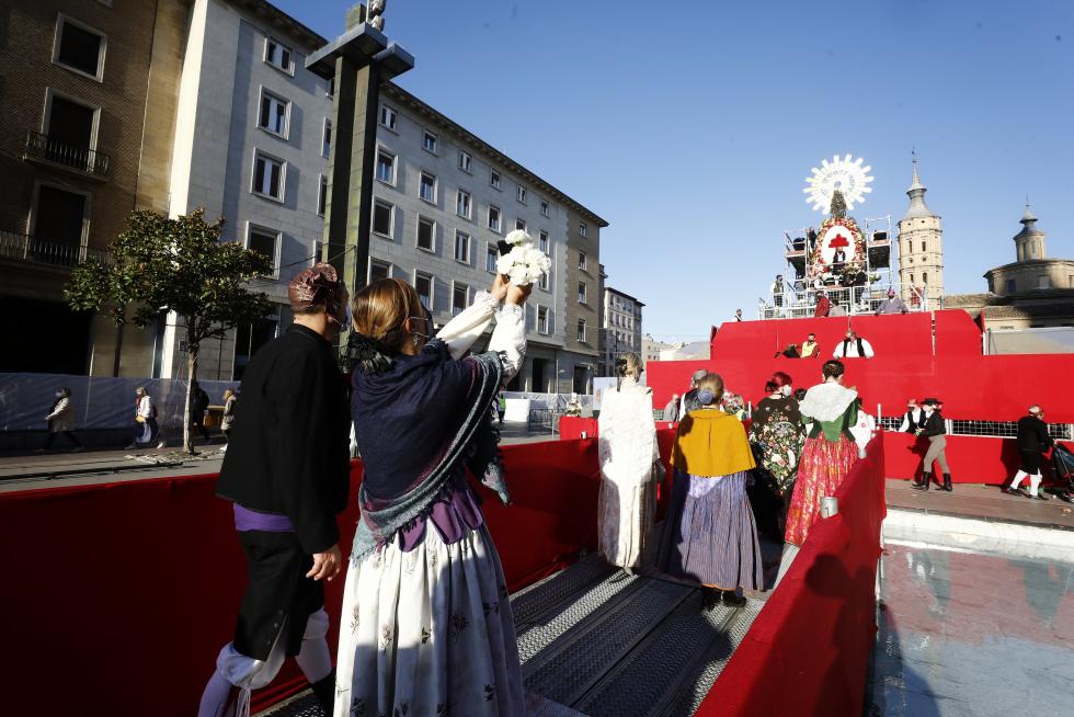 Conforme avanza la mañana el manto y la estructura de la Virgen se van cubriendo de flores. La afluencia de oferentes mantiene las distancias pero no cesa.