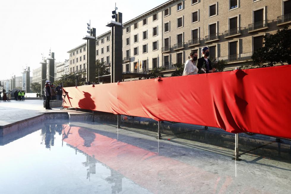 Conforme avanza la mañana el manto y la estructura de la Virgen se van cubriendo de flores. La afluencia de oferentes mantiene las distancias pero no cesa.