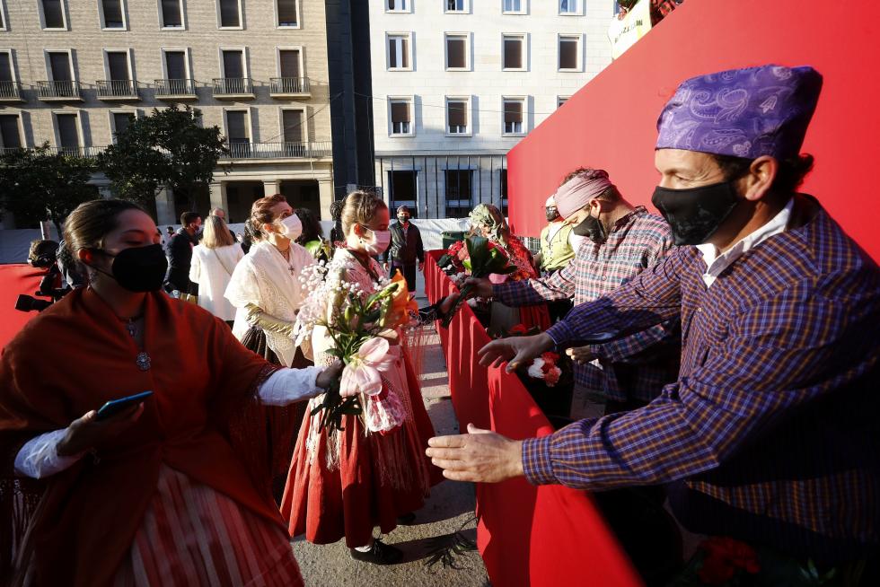 Conforme avanza la mañana el manto y la estructura de la Virgen se van cubriendo de flores. La afluencia de oferentes mantiene las distancias pero no cesa.