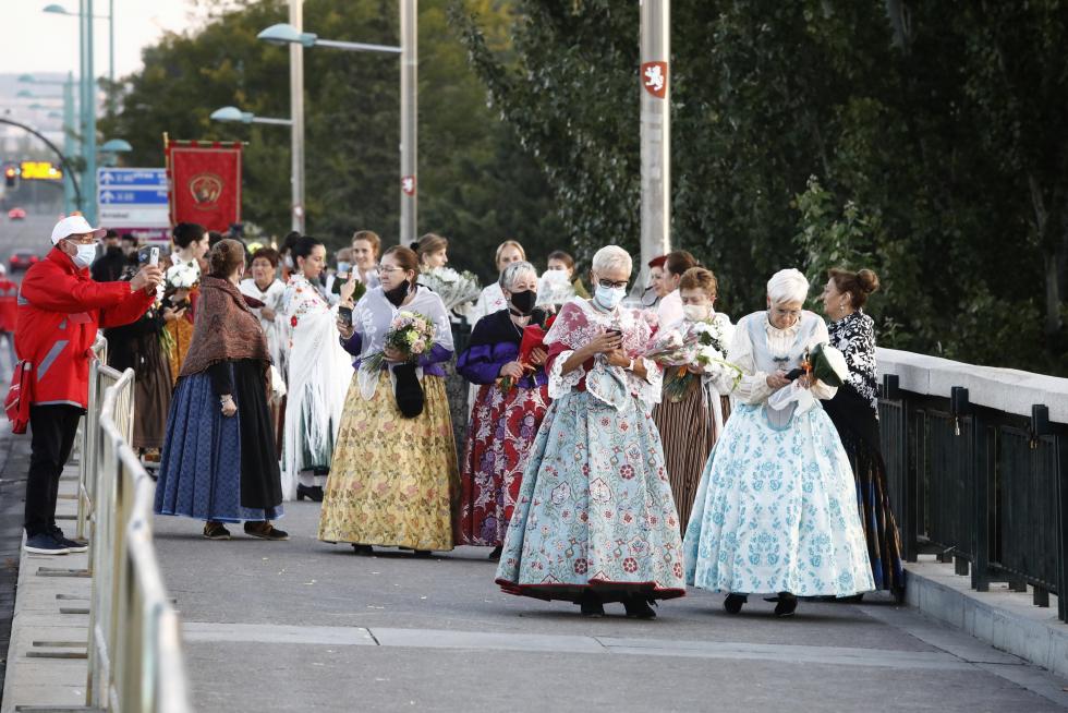 La Ofrenda va avanzando, el manto de la Virgen se está cubriendo ya y el color inunda la plaza. Al otro lado de las vallas, algunos curiosos intentan vislumbrar lo que ocurre.