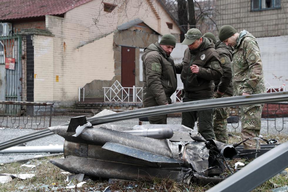Policias ucranianos inspeccionan los restos de un misil en las calles de Kiev.