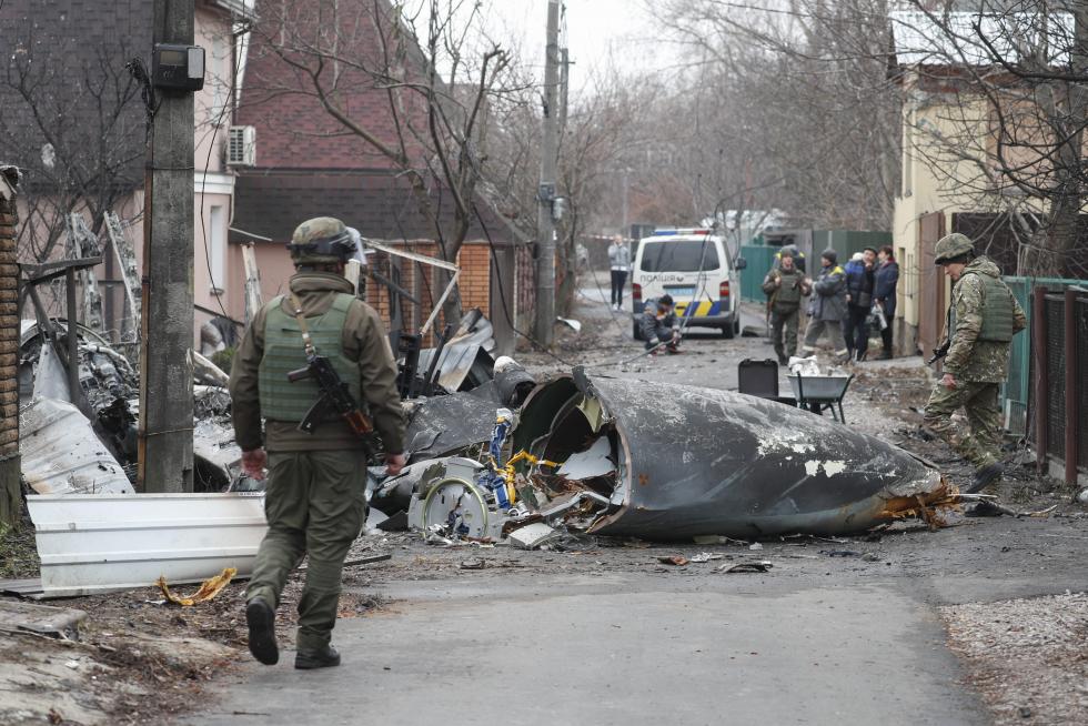 Soldados ucranianos observan los restos de un avión militar que fue derribado durante la noche en Kiev