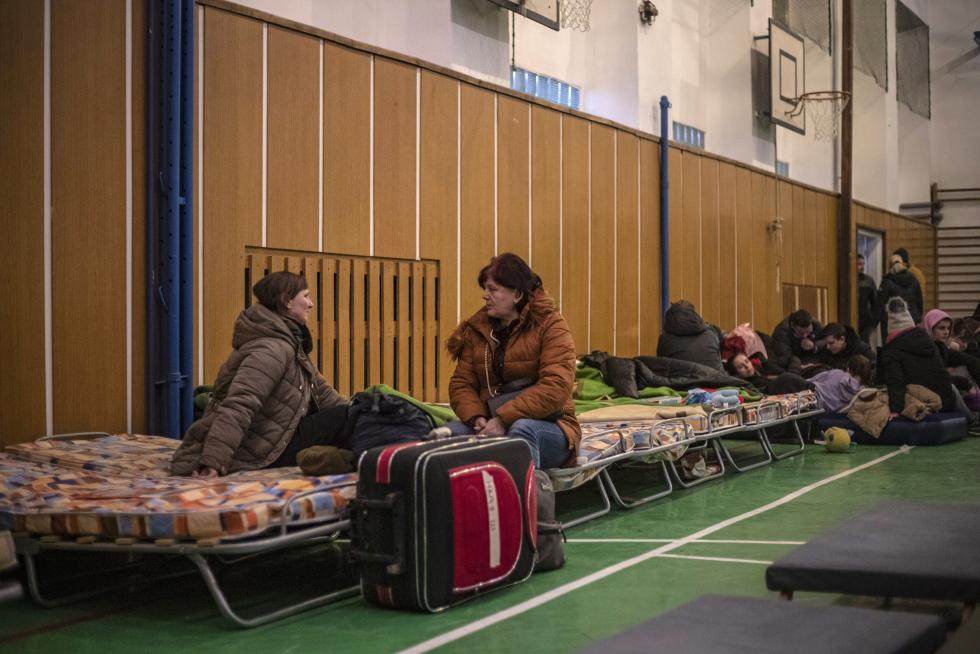 Ciuadadanos ucranianos se preparan para pasar la noche en un polideportivo eslovaco.