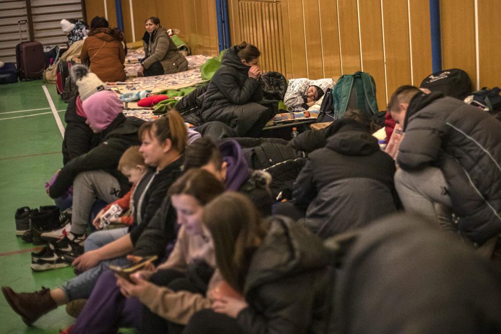 Ciuadadanos ucranianos se preparan para pasar la noche en un polideportivo eslovaco.