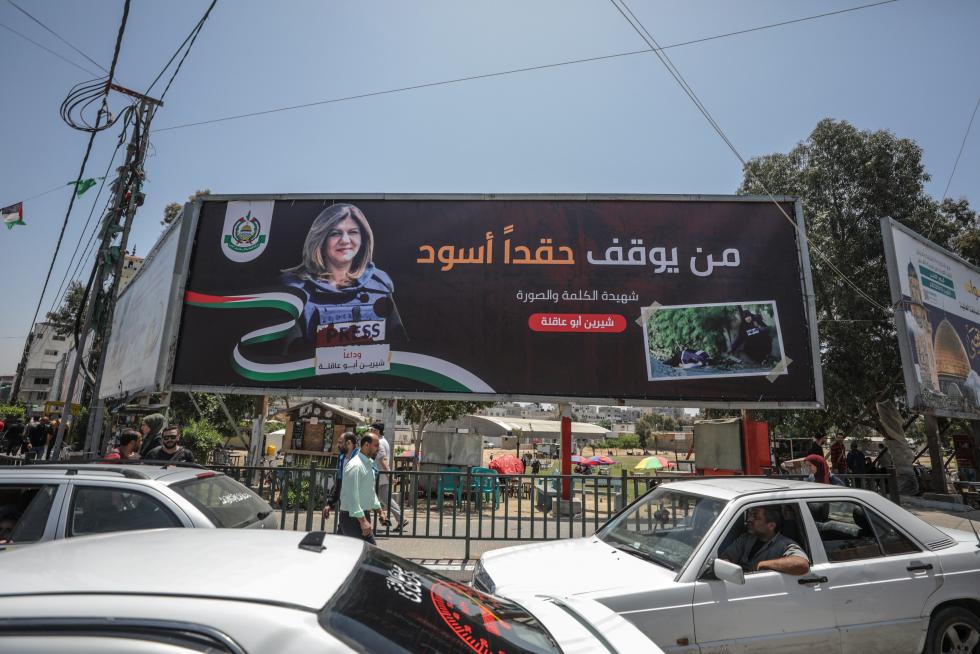 Gaza (-), 12/05/2022.- Palestinians cross in front of a large poster for Al Jazeera journalist Shireen Abu Akleh in Gaza City, 12 May 2022. According to the Palestinian health ministry, Al Jazeera journalist Shireen Abu Akleh was shot and killed on 11 May 2022 by Israeli forces during an Israeli raid in the West Bank town of Jenin. EFE/EPA/MOHAMMED SABER
MIDEAST PALESTINIANS SHIREEN ABU AKLEH