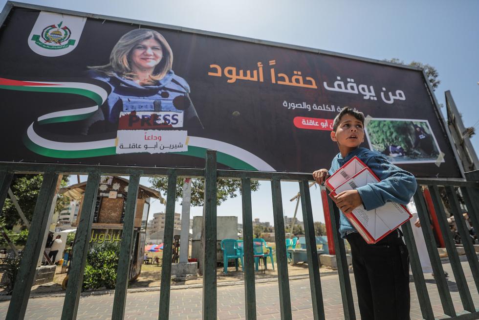Gaza (-), 12/05/2022.- Palestinians cross in front of a large poster for Al Jazeera journalist Shireen Abu Akleh in Gaza City, 12 May 2022. According to the Palestinian health ministry, Al Jazeera journalist Shireen Abu Akleh was shot and killed on 11 May 2022 by Israeli forces during an Israeli raid in the West Bank town of Jenin. EFE/EPA/MOHAMMED SABER
MIDEAST PALESTINIANS SHIREEN ABU AKLEH