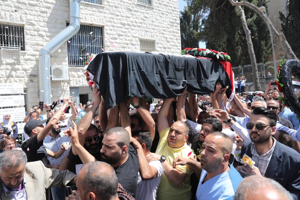 Honour guards carry the casket of Al Jazeera journalist Shireen Abu Akleh, who was killed during an Israeli raid, as Palestinians bid their farewell in Ramallah in the Israeli-occupied West Bank May 12, 2022. REUTERS/Mohamad Torokman TPX IMAGES OF THE DAY ISRAEL-PALESTINIANS/JOURNALIST-FAREWELL