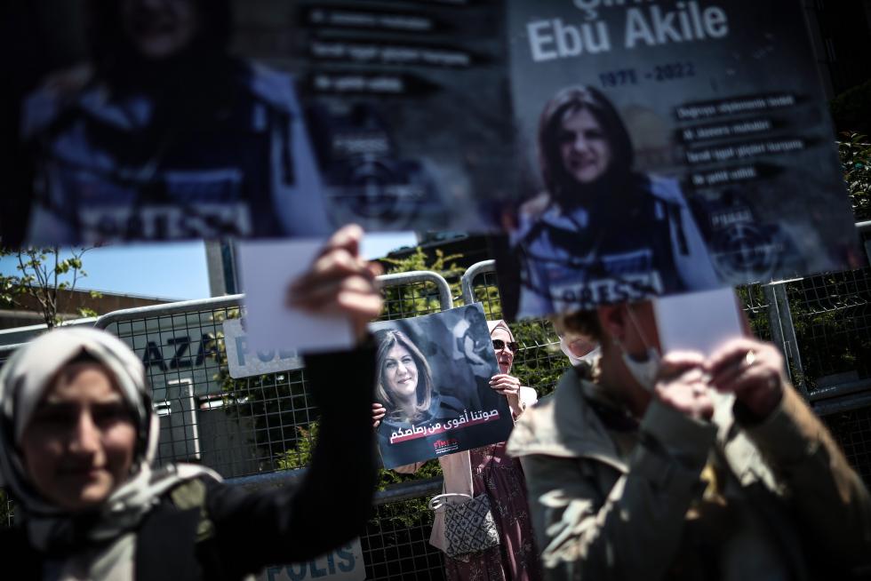 A protester carries a picture of Al Jazeera reporter Shireen Abu Akleh, who was killed during an Israeli raid in Jenin in the occupied West Bank, during a march rally against military rule following a coup in Khartoum, Sudan May 12, 2022. REUTERS/Mohamed Nureldin Abdallah SUDAN-POLITICS/