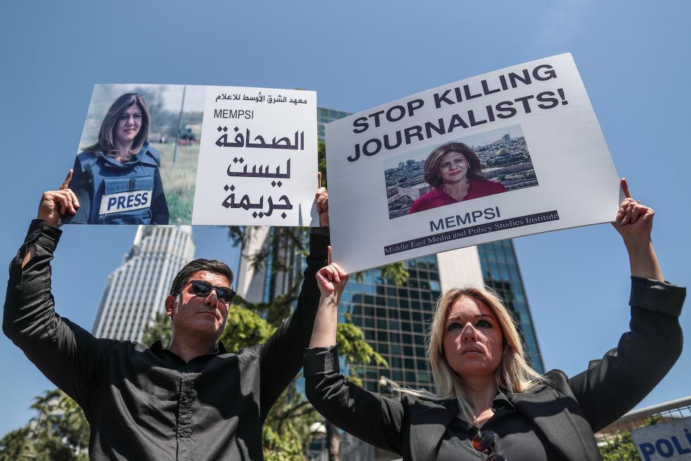 A protester carries a picture of Al Jazeera reporter Shireen Abu Akleh, who was killed during an Israeli raid in Jenin in the occupied West Bank, during a march rally against military rule following a coup in Khartoum, Sudan May 12, 2022. REUTERS/Mohamed Nureldin Abdallah SUDAN-POLITICS/