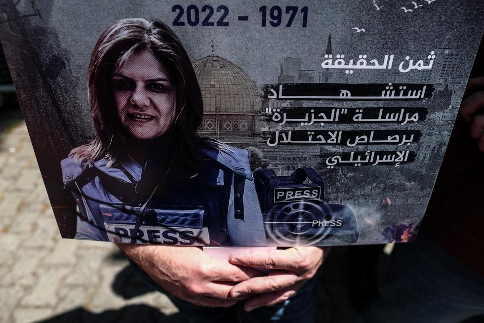A protester carries a picture of Al Jazeera reporter Shireen Abu Akleh, who was killed during an Israeli raid in Jenin in the occupied West Bank, during a march rally against military rule following a coup in Khartoum, Sudan May 12, 2022. REUTERS/Mohamed Nureldin Abdallah SUDAN-POLITICS/