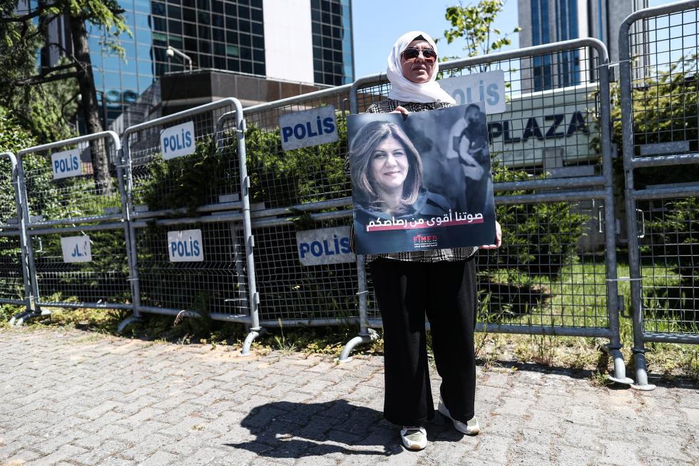 A protester carries a picture of Al Jazeera reporter Shireen Abu Akleh, who was killed during an Israeli raid in Jenin in the occupied West Bank, during a march rally against military rule following a coup in Khartoum, Sudan May 12, 2022. REUTERS/Mohamed Nureldin Abdallah SUDAN-POLITICS/