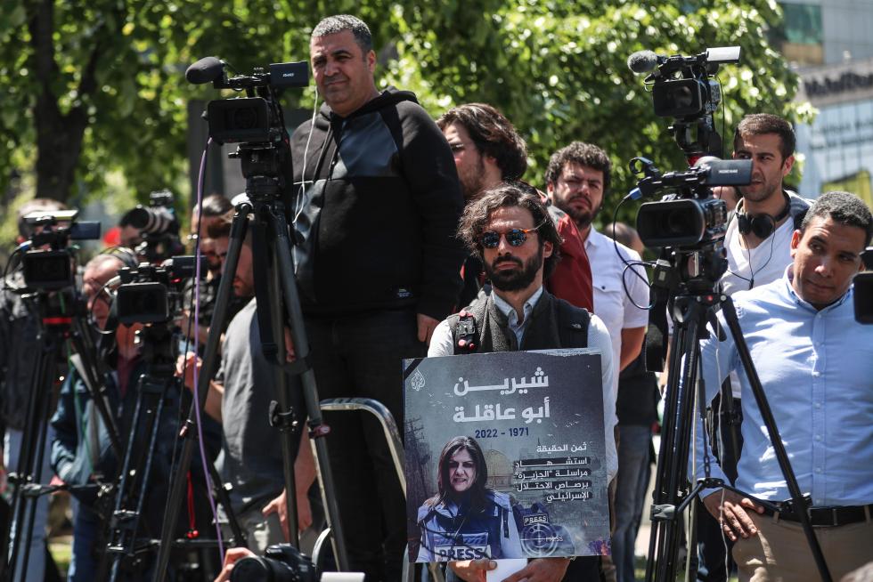 A protester carries a picture of Al Jazeera reporter Shireen Abu Akleh, who was killed during an Israeli raid in Jenin in the occupied West Bank, during a march rally against military rule following a coup in Khartoum, Sudan May 12, 2022. REUTERS/Mohamed Nureldin Abdallah SUDAN-POLITICS/