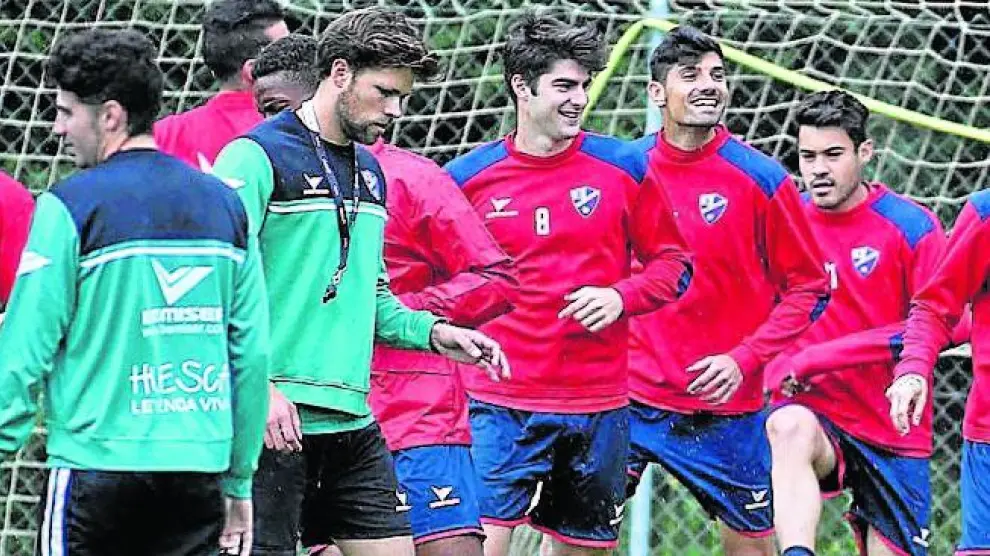 La plantilla del Huesca calienta en el arranque del entrenamiento de ayer, a las órdenes de Marcos Marcen.