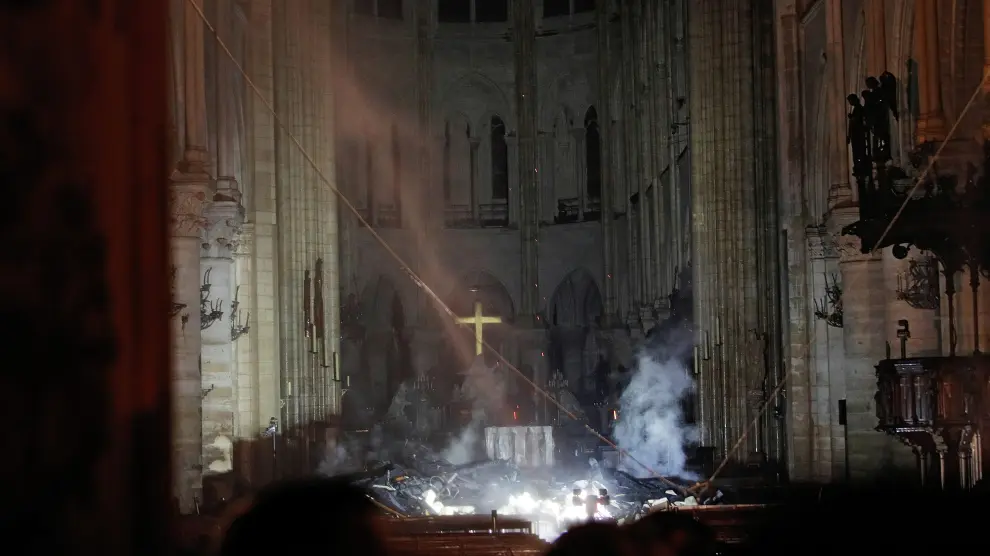 Smoke rises around the altar in front of the cross inside the Notre Dame Cathedral as a fire continues to burn in Paris, France, April 16, 2019.   REUTERS/Philippe Wojazer/Pool     TPX IMAGES OF THE DAY [[[REUTERS VOCENTO]]] FRANCE-NOTREDAME/