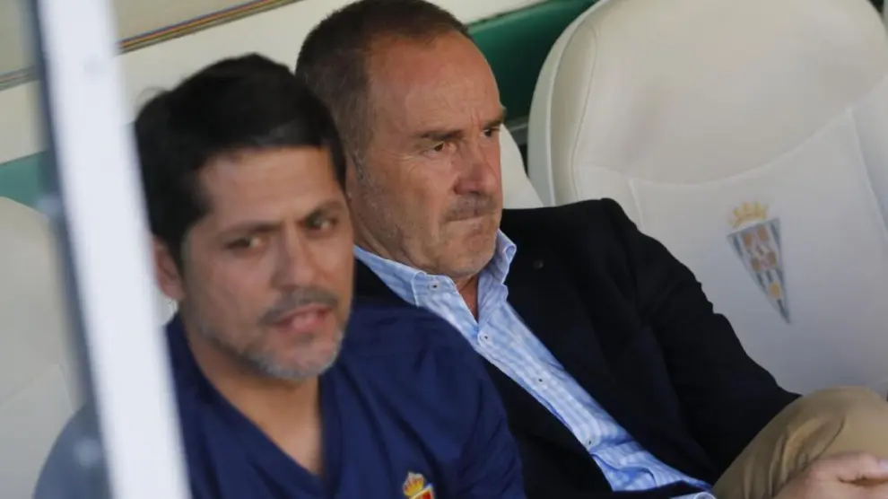 Víctor Fernández, con gesto preocupado, sentado en el banquillo de El Arcángel junto a José Luis Loreto, el segundo técnico del Real Zaragoza.