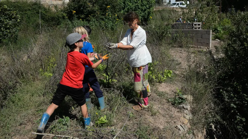 Delfi Ruiz, en el huerto de la escuela de Olba (Teruel), con tres de sus alumnos