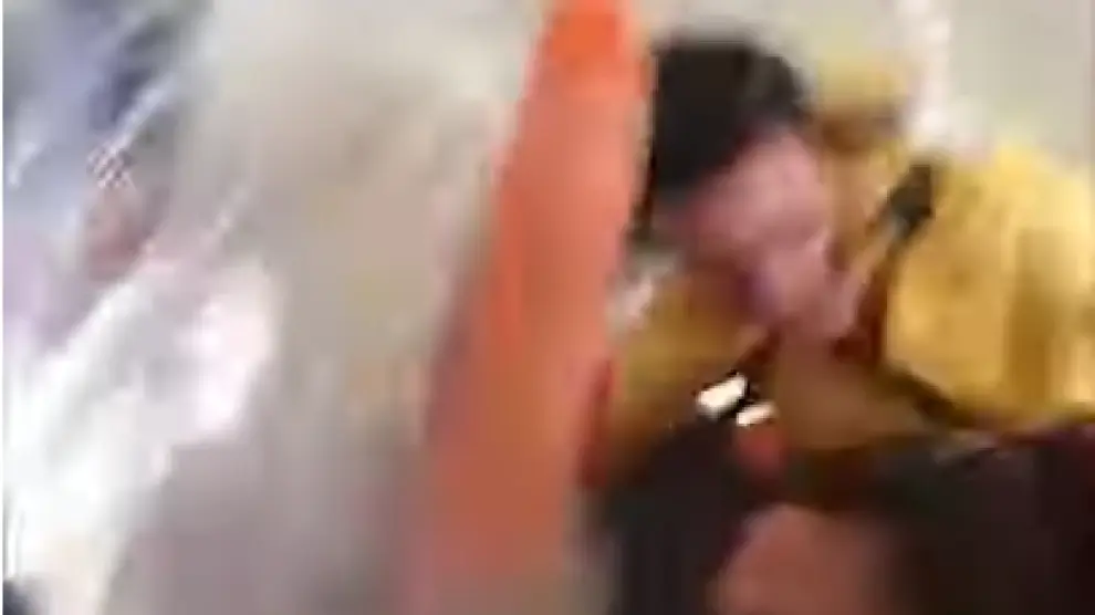Momento del vídeo en el que la azafata se golpea la cabeza contra el techo del avión.