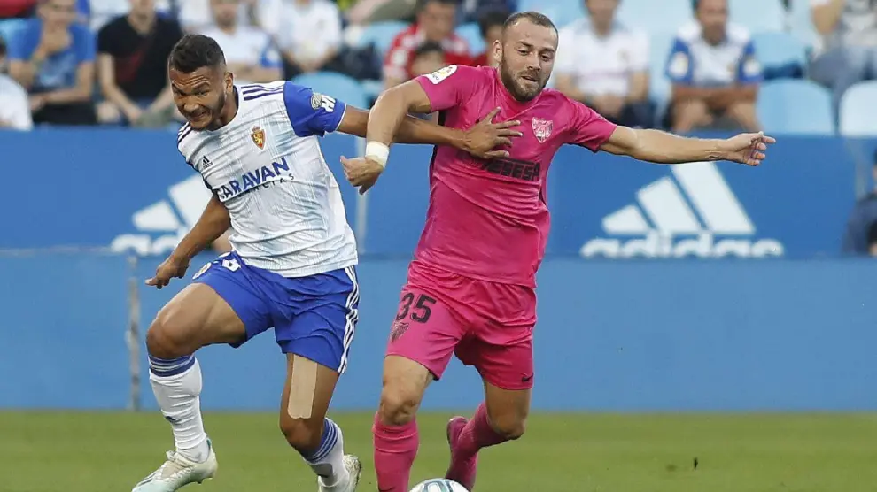 Luis Suárez pugna con el malacitano Keidi Bare en el partido Real Zaragoza-Málaga de este jueves.