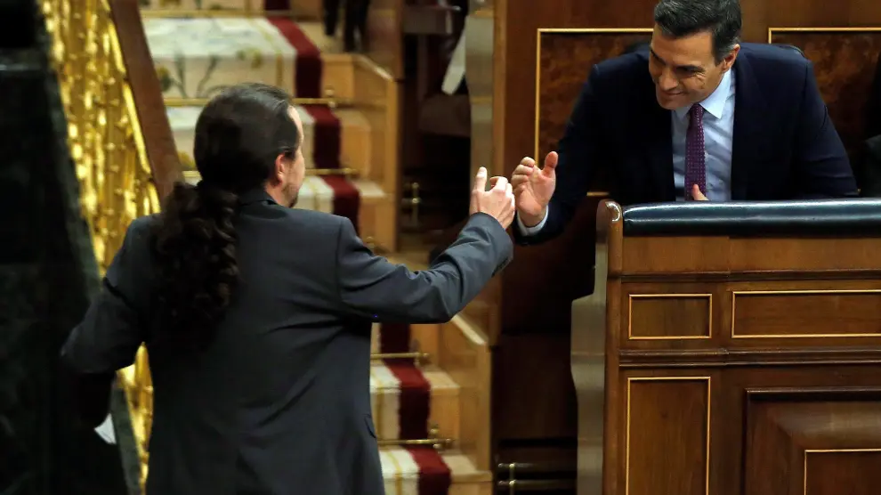 Pedro Sánchez y Pablo Iglesias se dan la mano.