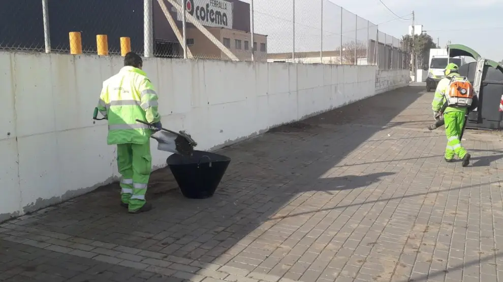 La brigada de limpieza de FCC limpia las aceras de la calle de Baleares.
