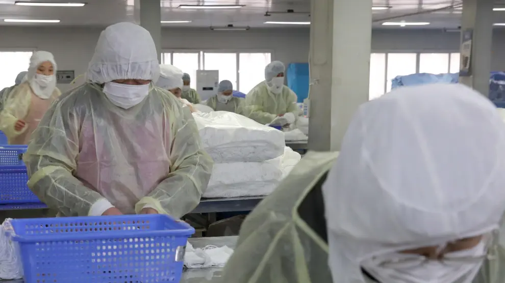 Varios trabajadores, en una fábrica de mascarillas en la ciudad china de Nantong.