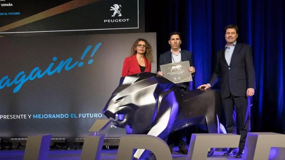 Francisco de Ayerbe (en el centro), gerente de PSA Retail Zaragoza, recibiendo el premio de Helene Bouteleau, directora general de Peugeot España, y Jaime Piedrola, director de ventas de Peugeot España.