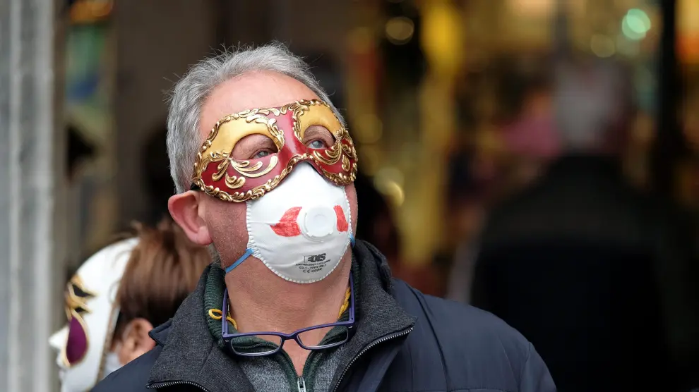 A masked carnival reveller wears protective face mask at Venice Carnival, which the last two days of, as well as Sunday night's festivities, have been cancelled because of an outbreak of coronavirus, in Venice, Italy February 23, 2020. REUTERS/Manuel Silvestri [[[REUTERS VOCENTO]]] CHINA-HEALTH/ITALY-VENICE
