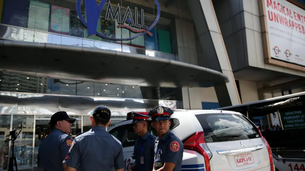 Varios policías, delante de una de las entradas al centro comercial.