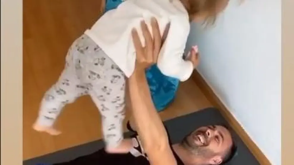 Atienza levanta a su hija con los brazos.