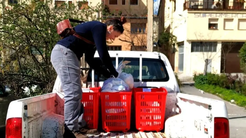 Una empleada municipal reparte alimentos en Aínsa.