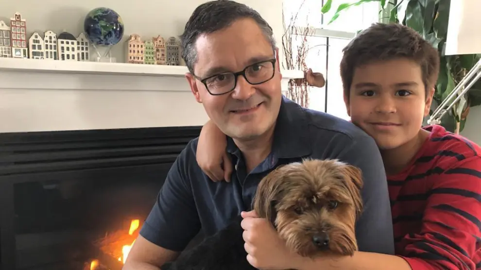 Santiago Comella junto a su hijo pequeño y su perro en su vivienda de Boston.