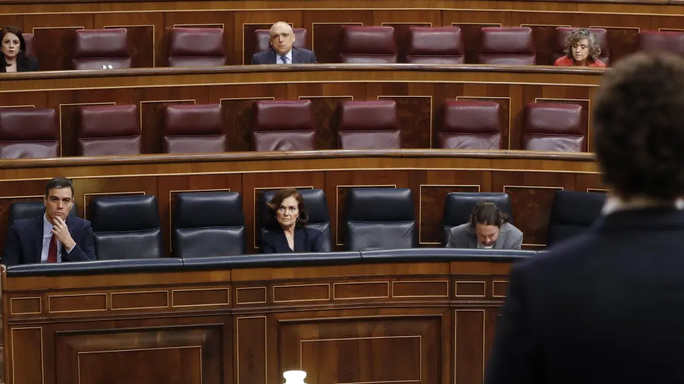 El presidente del Gobierno escucha a Pedro Sánchez (de espaldas) en la sesión de control.