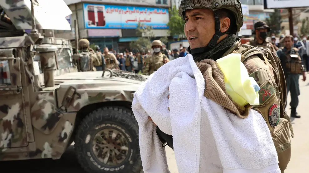 Un soldado evacua a un bebé del hospital atacado en Kabul.