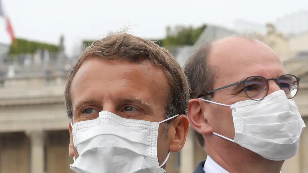 El presidente francés Emmanuel Macron y el primer ministro Jean Castex both wearing, con mascarilla, durante el desfile que conmemora la toma de la Bastilla.