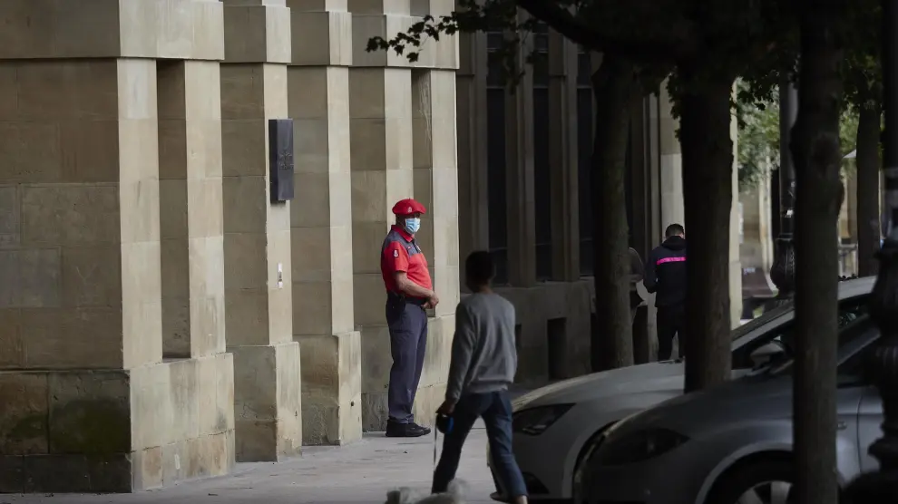 Un agente de la Policía Foral con mascarilla en los soportales de una céntrica calle de Pamplona.