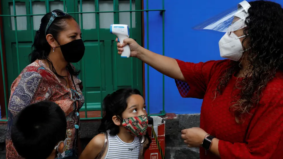 Toma de temperatura a una familia en la visita a la Casa Azul de Frida Kahlo en Ciudad de México.