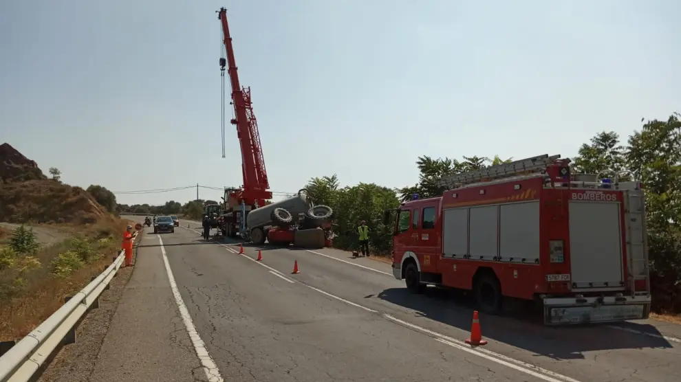 Un camión de bomberos y una grúa han permanecido en la carretera hasta que se han podido llevar el tractor.