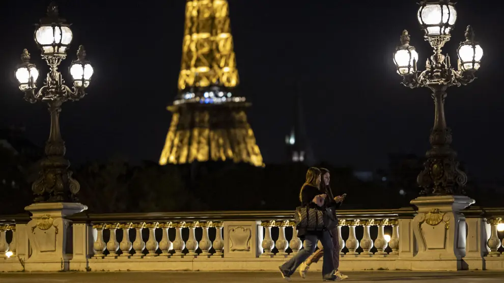 Dos jóvenes caminan por París momentos antes del inicio del toque de queda en la ciudad.