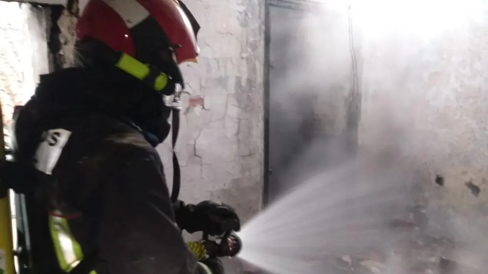 Un bombero trabaja para sofocar el incendio registrado en una vivienda de Utrillas.