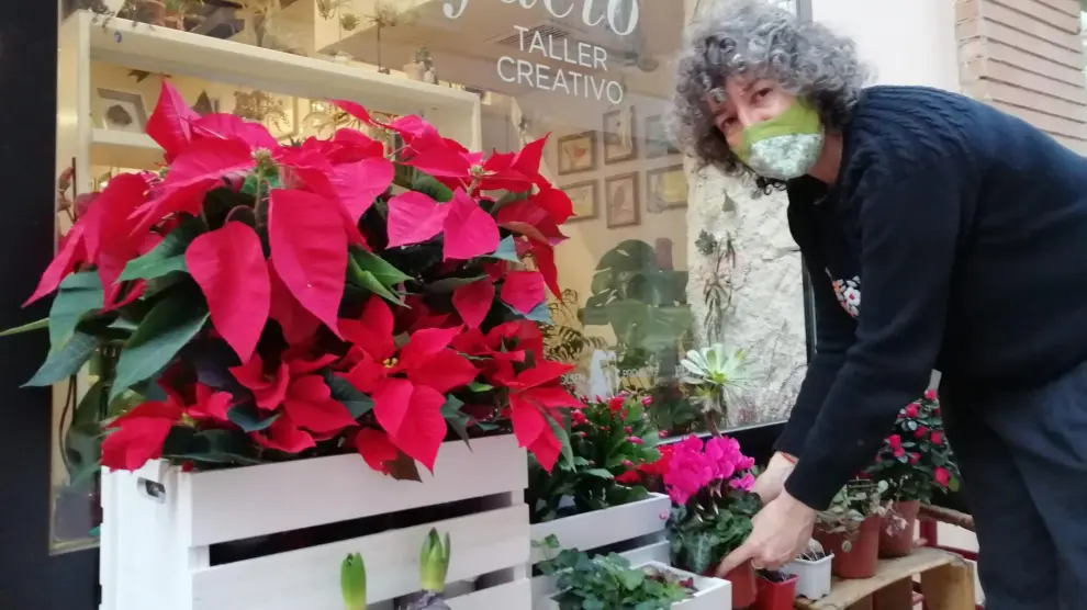 Ruth Albero arregla unas flores en la puerta de Artefacto, en la calle de San Pablo.