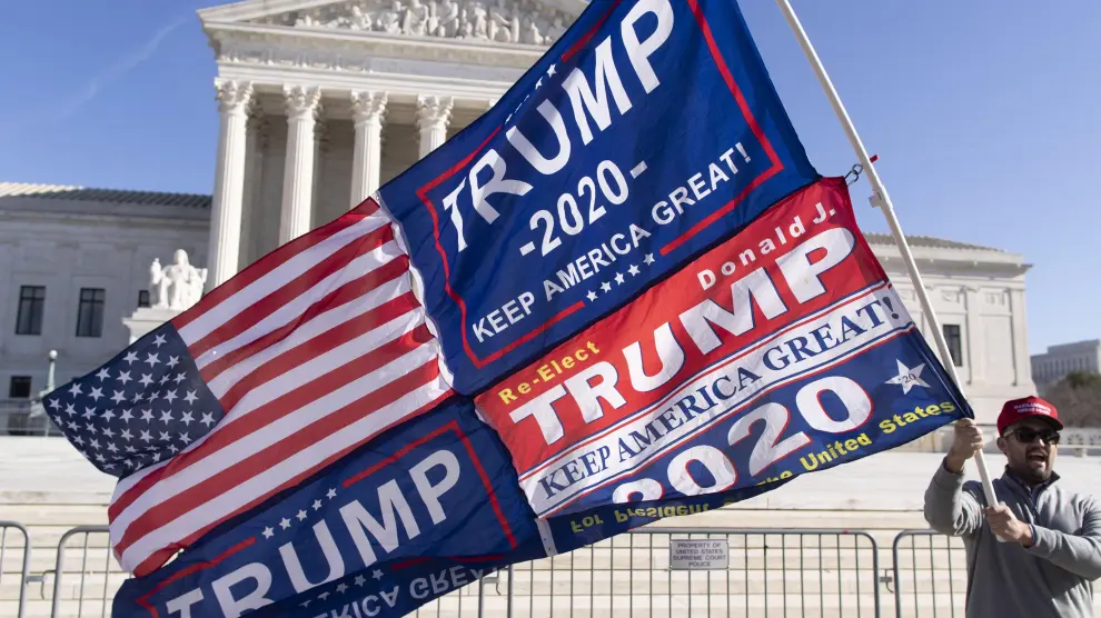 Un seguidor de Trump ondea una bandera de Estados Unidos delante del Tribunal Supremo, en Washington.