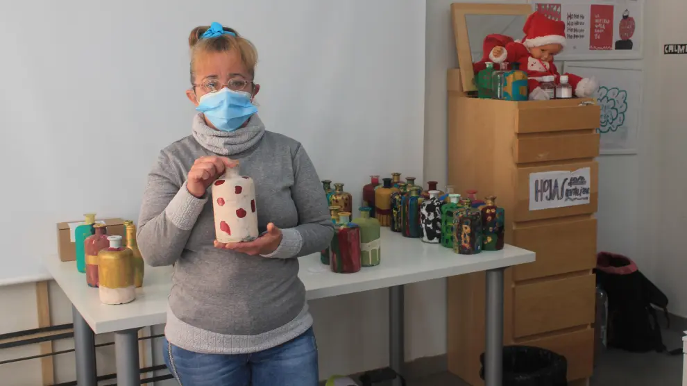 Cristina García, usuaria de Atades, enseña una de las botellas que ha decorado estos días.
