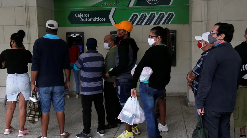 Varias personas hacen fila para sacar dinero de un cajero automático en La Habana.