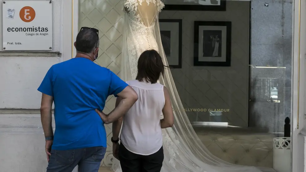 Una pareja mira un escaparate de una tienda de vestidos de novia en Zaragoza, en una imagen de archivo.