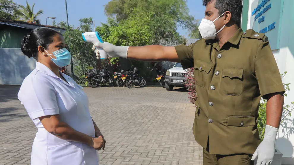 Un inspector toma la temperatura a una sanitaria, este sábado en Colombo (Sri Lanka).