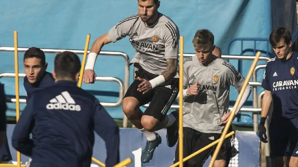 Álvaro Ratón, en pleno salto durante el último entrenamiento del Real Zaragoza, por delante del joven portero Carlos Azón, su pareja en la convocatoria de este domingo en Málaga.