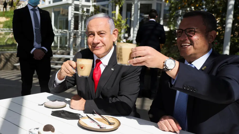 Israeli Prime Minister Benjamin Netanyahu drinks coffee with Mayor of Jerusalem, Moshe Leon, as they sit at a cafe while Israel further eases coronavirus disease (COVID-19) restrictions in Jerusalem