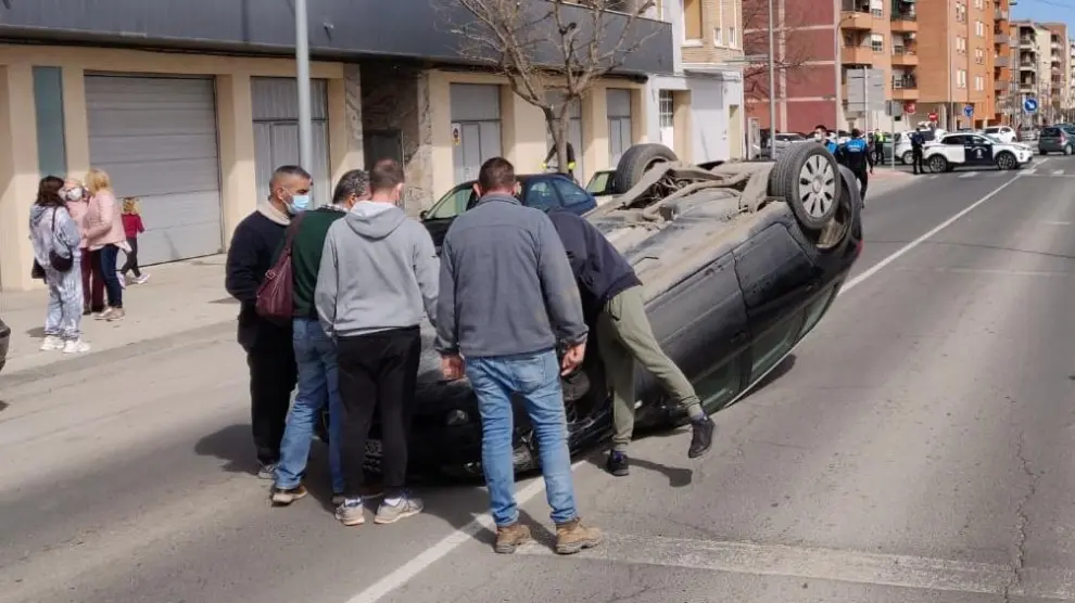 El coche ha quedado volcado en medio de la calzada tras colisionar con otros dos coches aparcados en la avenida de Aragón, en Fraga.