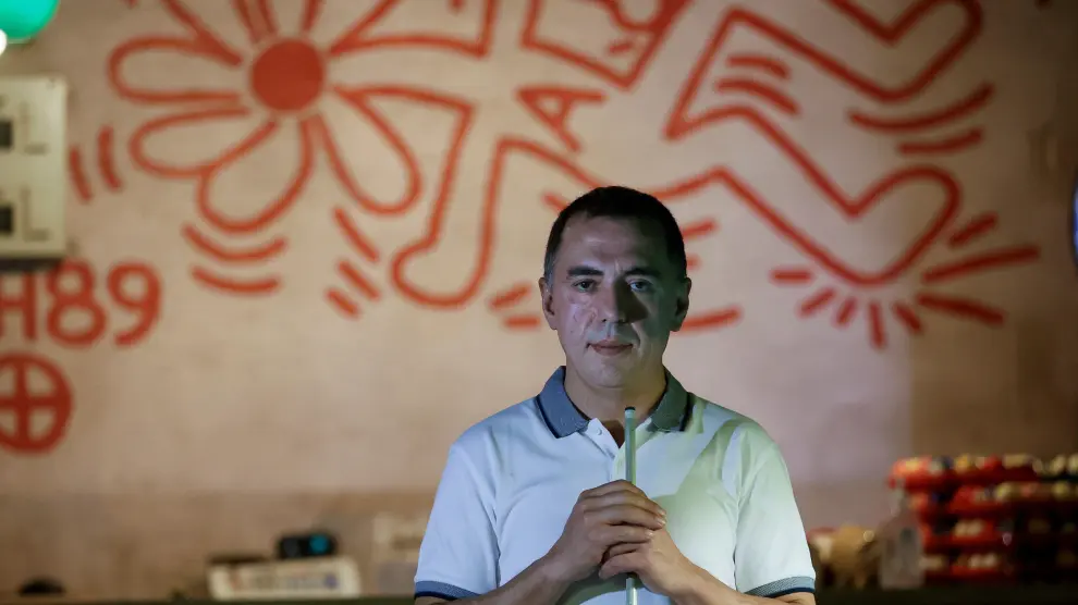 El propietario de Billares Ars, Gabriel Carral, posa en su local junto al mural que el artista neoyorkino Keith Haring