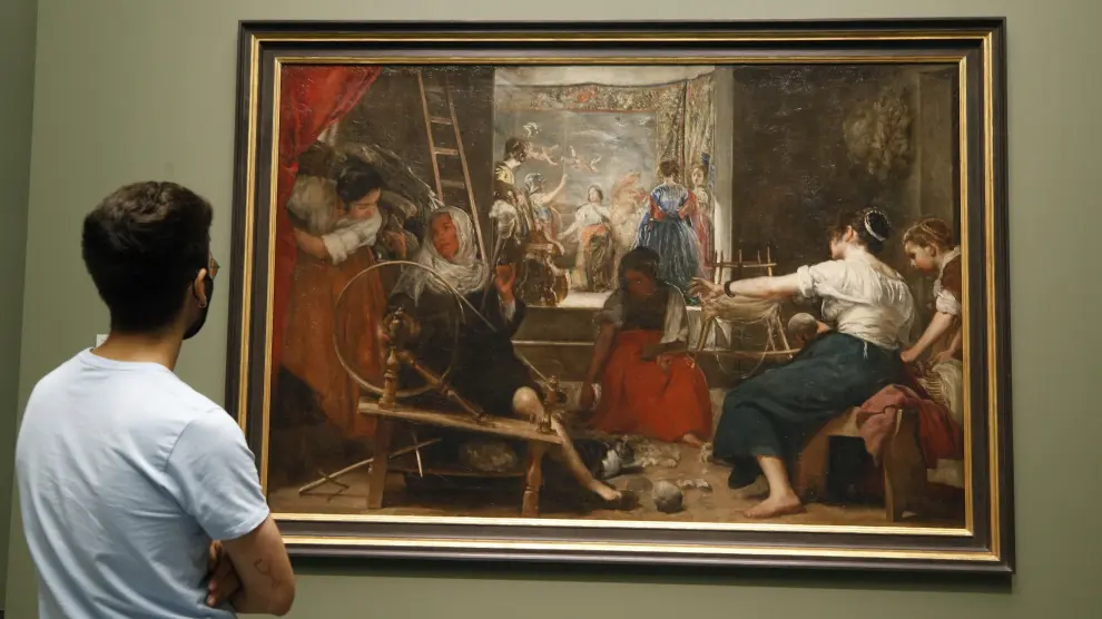Un visitante observa "Las hilanderas" de Velázquez, que puede contemplarse desde este lunes en el Museo del Prado tal y como Velázquez quiso que se viera